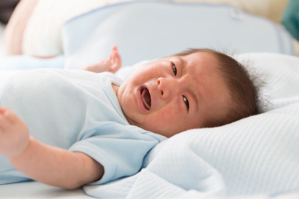 Weinendes Baby am Abend im Bett